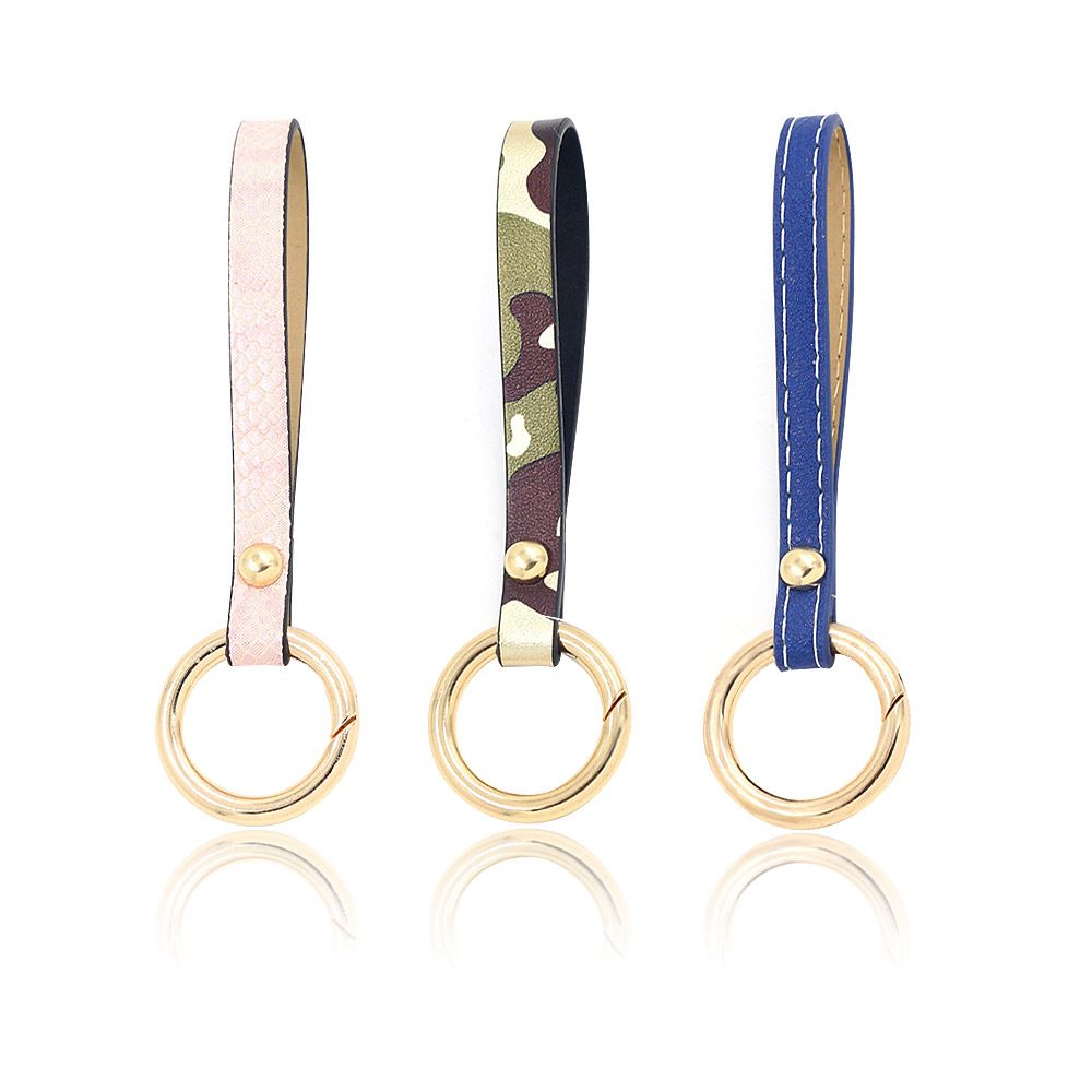 Três chaveiros com alça de pulso em couro PU em cores diferentes, cada um apresentando um elegante chaveiro dourado, perfeito para complementar carteiras ou bolsas.