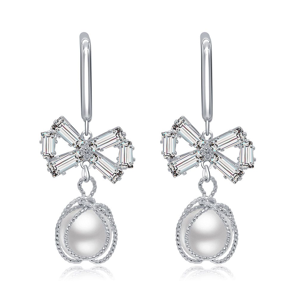 Pendientes de perla con gancho en forma de lazo que presentan copas en forma de flor con piedras preciosas transparentes cortadas en baguette y elegantes perlas en forma de lágrima.