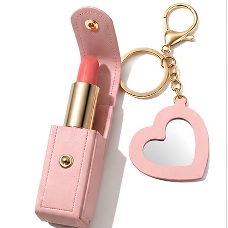 Pink leather lipstick holder case open showing lipstick and attached heart mirror charm keychain.