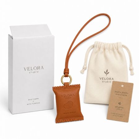 Custom snack-shaped leather bag charm with branded gift box, canvas drawstring pouch, and kraft paper hang tag.