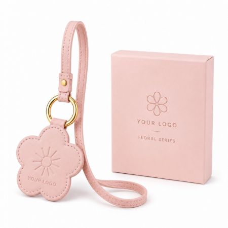 Pink floral leather bag charm with embossed logo, gold hardware, and matching customized gift retail packaging.