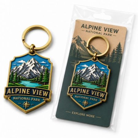 Llavero de esmalte de recuerdo personalizado con baño de oro, que presenta un paisaje de parque nacional alpino en una tarjeta de respaldo.