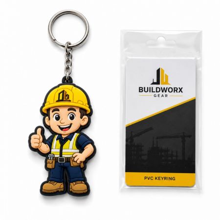 Llaveros promocionales personalizados de PVC con un casco amarillo al lado de un empaque de tarjeta de plástico sellada.