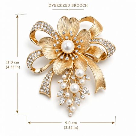 Oversized Brooch - Oversized gold floral ribbon brooch measuring 11.0 cm by 9.0 cm featuring crystals and pearl drops.