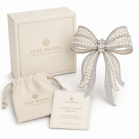 Luxe bridal oversized silver bow brooch completely embellished with white pearls and rhinestones for weddings.