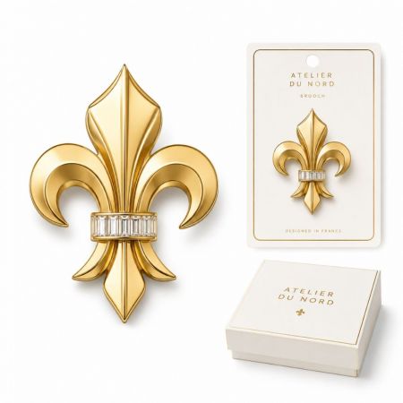 Atelier du Nord French design gold fleur-de-lis brooch with baguette crystals, premium boutique packaging display.