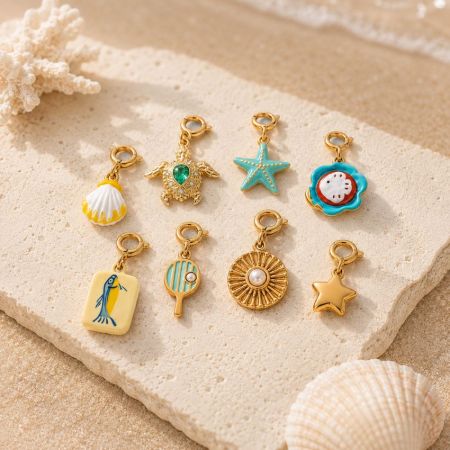 Close up of 18K PVD gold plated beach charms with hand painted enamel and clear CZ accents for B2B supply.