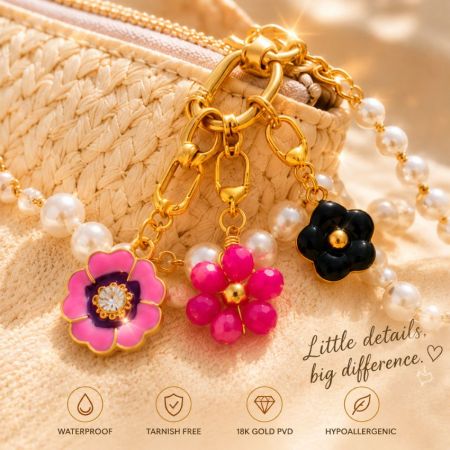 Enamel flower clip-on charms attached to a pearl chain and woven purse, demonstrating versatile fashion applications.