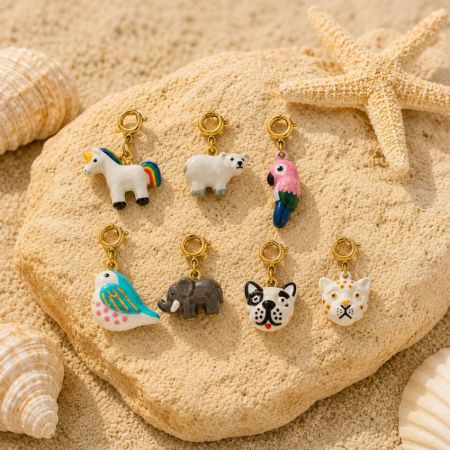 Seven different enamel animal charm clips arranged on a rock next to a starfish, offering a versatile custom mix and match collection.