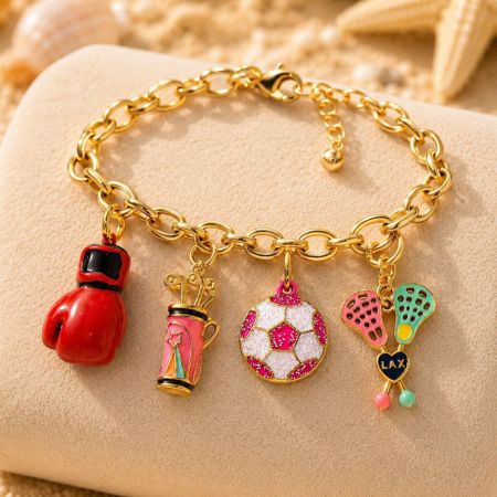 Charms esportivos de clipe presos a uma pulseira de corrente dourada, destacando opções versáteis de mix e match.