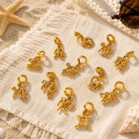 Douze charms du zodiaque disposés dans une boîte cadeau blanche personnalisée avec des options d'emballage de marque privée pour les marques OEM ODM.