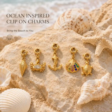 Stainless steel clip-in charms collection on beach sand, highlighting wholesale low MOQ options.