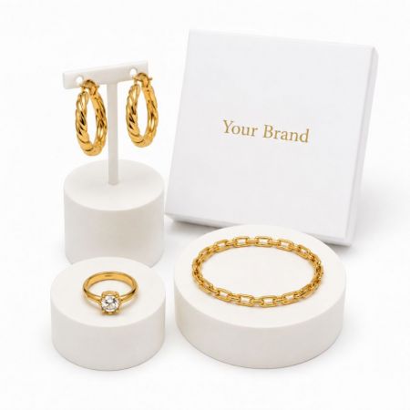 Chunky gold twisted hoop earrings, link bracelet, and CZ ring with custom private label boxes for B2B buyers.