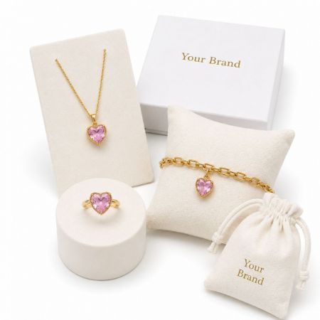 Pink heart gemstone necklace, ring, and charm bracelet sets with branded private label pouches and boxes.