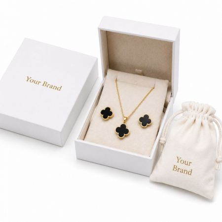 Gold and black clover necklace and earring sets in custom presentation boxes for private label OEM jewelry.
