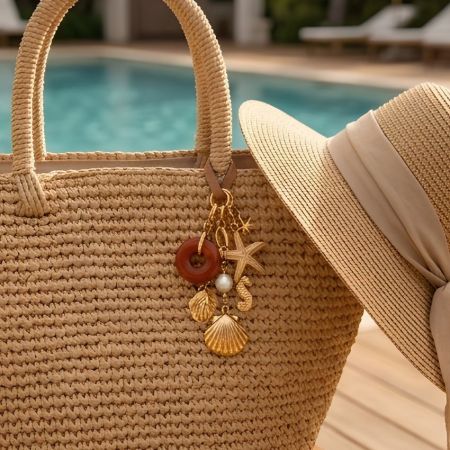 Groupe de charme de sac de plage personnalisé avec des étoiles de mer en or, des coquillages et un anneau en agate attachés à un sac en paille.