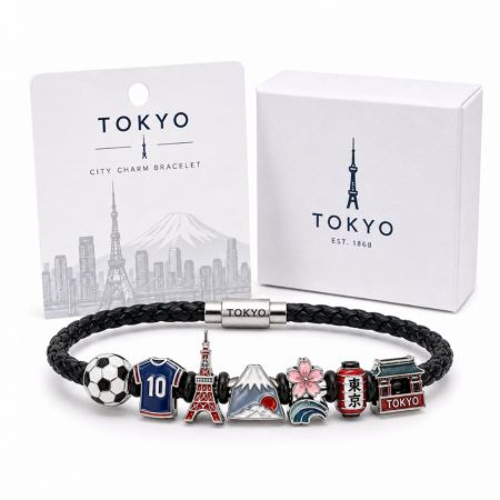 Tokyo city charm bracelet in black braided leather featuring custom enamel Mount Fuji, Tokyo Tower, and sakura charms.