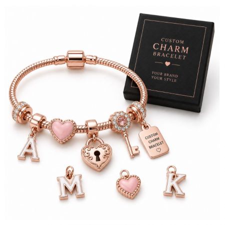 Custom rose gold initial charm bracelet with pink heart and lock charms alongside a branded jewelry box.