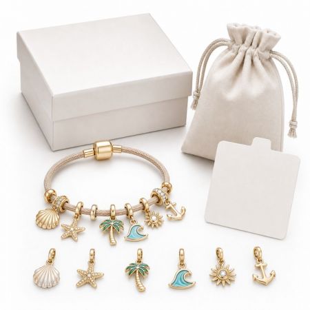 Wholesale beach theme charm bracelet with gold palm tree, starfish, and wave charms, complete with gift box packaging.