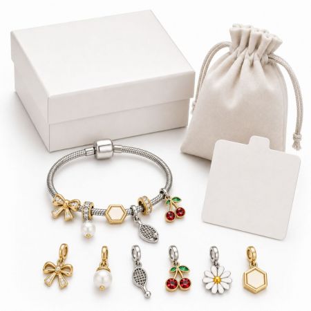 Custom enamel cherry and bow charm bracelet, shown with white gift box and jewelry pouch for retail display.