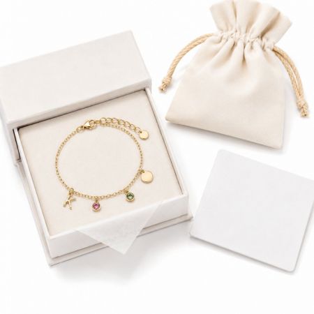 Gold initial charm bracelet featuring colorful crystals in a presentation box, customizable for retail brands.