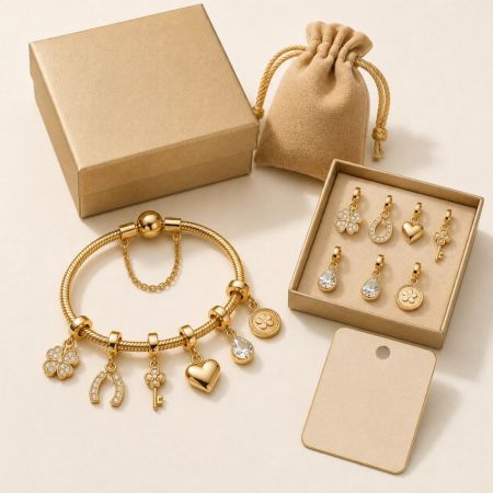 Lucky gold charm bracelet featuring horseshoe, key, and clover pendants, paired with micro-fiber pouch and boxes.