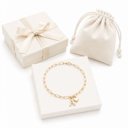 Gold paperclip chain bracelet with a heart and initial A pendant, ideal for custom brand jewelry ordering.
