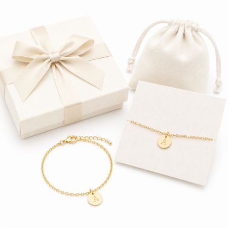 Delicate gold chain bracelets with round stamped initial charms, ideal for corporate gifting and wholesale supply.