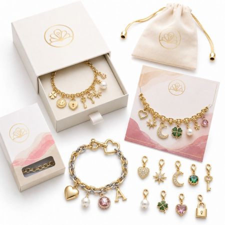 Assorted gold and silver charm bracelets with custom packaging boxes and individual lobster clasp pendants.