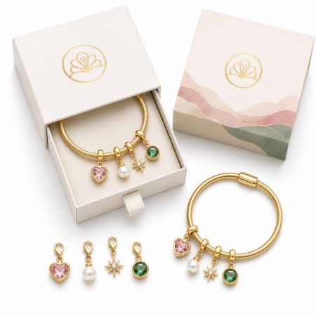 Gold snake chain bangles with interchangeable gemstone beads and charms, displayed with elegant slide-out gift boxes.