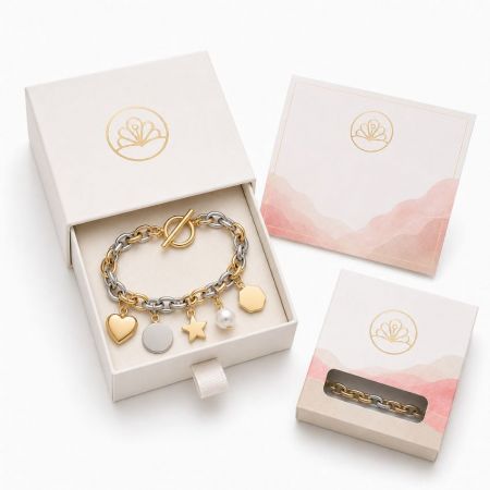 Two-tone gold and silver link bracelet with toggle clasp and blank geometric pendants for custom engraving services.
