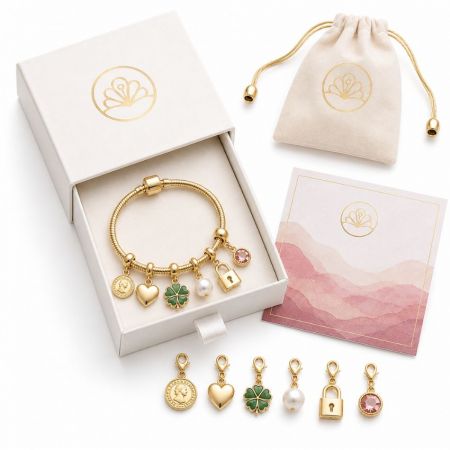 Gold European bead bracelet featuring custom lucky charms, shown with branded merchandise gift box and drawstring pouch.