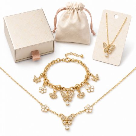 Gold butterfly charm necklace and bracelet set with rhinestone embellishments, ideal for retail merchandise.