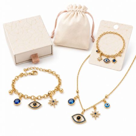 Gold evil eye charm necklace and link bracelet set featuring vibrant blue crystals for fashion vendors.