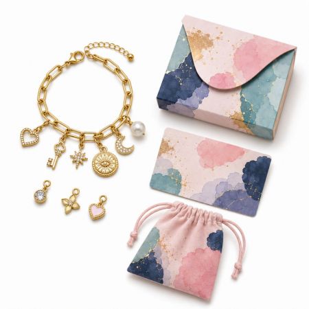 Gold link chain charm bracelet with heart, key, and pearl charms, showcasing an elegant jewelry packaging solution.