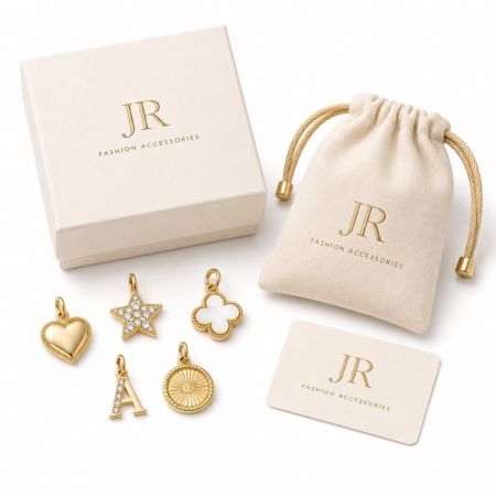 Assorted custom gold charms with private label pouch and box. JR Fashion wholesale jewelry supplier.