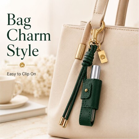 Green leather lip balm holder clip charm attached to a cream tote bag as a stylish everyday carry accessory.