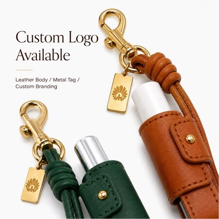 Close-up of green and brown PU leather lip balm holders with custom engraved gold metal logo tags for brand promotion.