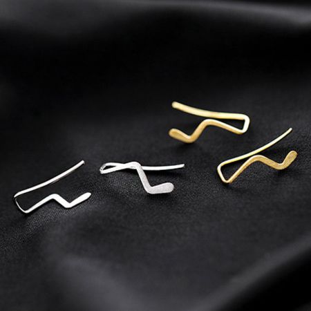 Orecchini a perno semplici a onda in argento sterling 925 (5 paia) - Una collezione di orecchini a perno semplici a onda in argento sterling 925, sia in finitura argento che oro, esposti su una superficie scura.