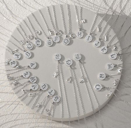 The complete alphabet set of the initial coin necklaces in sterling silver with cubic zirconia.