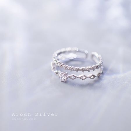 Un par de elegantes anillos de encaje de flores de plata S925 exhibidos para mostrar su detallada artesanía.