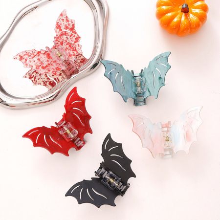 Un ensemble de pinces à cheveux en forme de chauve-souris de différentes couleurs, exposées à la vente.
