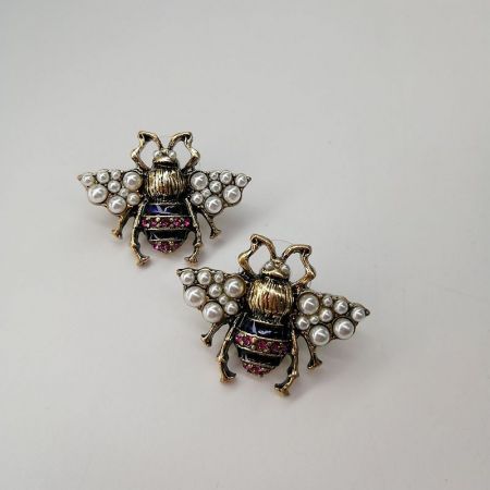 金で作られ、光沢のあるパールと宝石で飾られた蜂の形をしたブローチの別の角度。