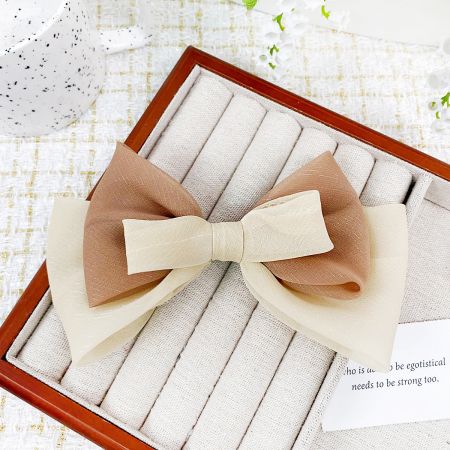 A sophisticated beige and brown ribbon bow hair clip.