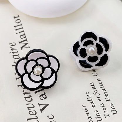 Mini Camellia Flower Acrylic Pearl Hair Clips - A pair of black and white camellia flower acrylic hair clips with pearl centers, displayed side-by-side to showcase both color options.