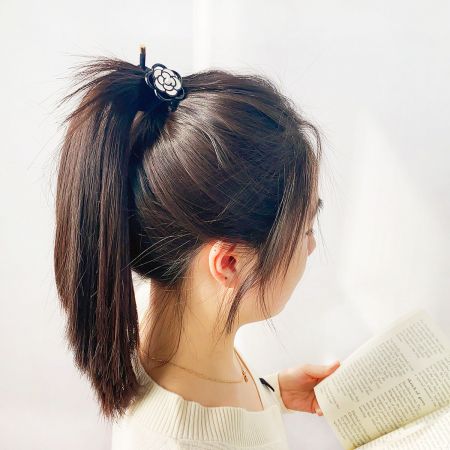 Black and White Camellia Flower Hair Tie Bands - A close-up of a black hair tie with a white camellia flower accent, elegantly securing a person's ponytail.