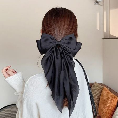 Um prendedor de cabelo em forma de laço de cauda longa preto, clássico e elegante.