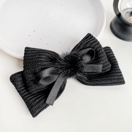 Elegant black knitted hair bow with a soft, fluffy center for a sophisticated look.