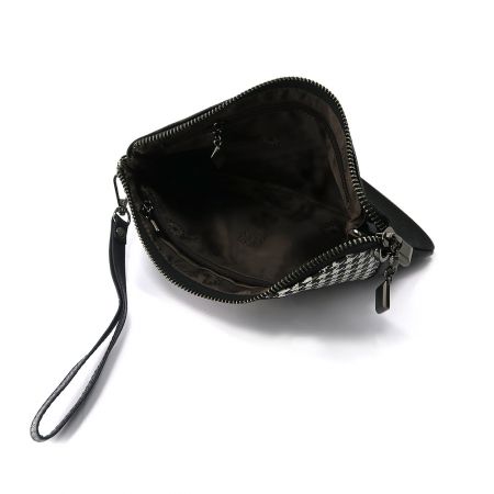 Interior view of the clutch bag showing the zippered pockets.