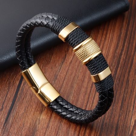 Primer plano de la pulsera de cuero negro con un llamativo cierre de acero inoxidable chapado en oro.